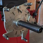 Close-up of a wheel balancer mounting head with a central threaded spindle and 5 adjustable mounting arms